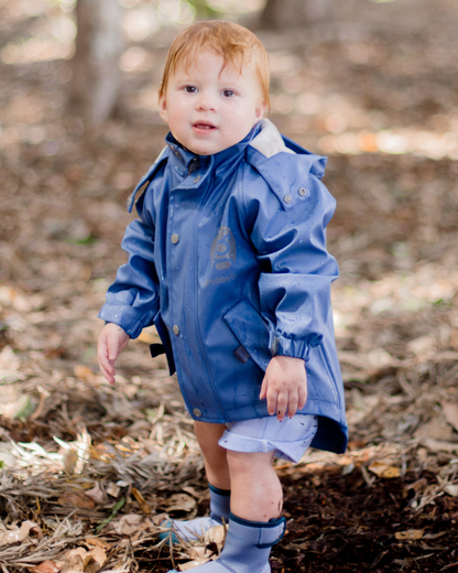 Toddler in blue waterproof rain jacket with mud guard, durable kids outdoor jacket for play